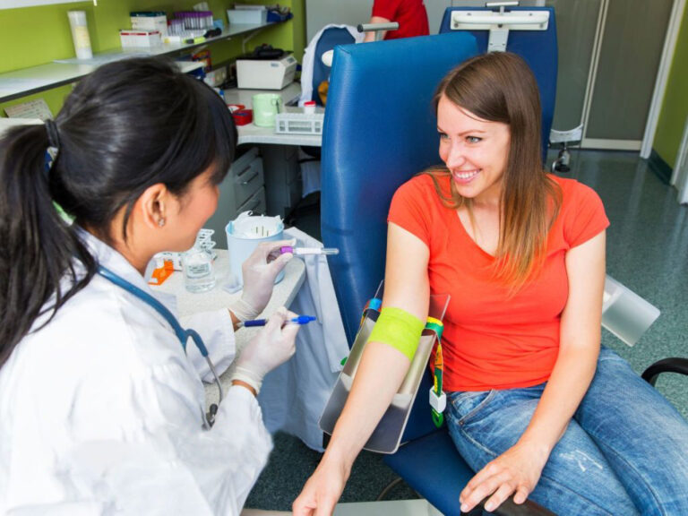 Nurse preparing woman for blood test.