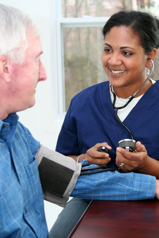 Nurse checking a patient's blood pressure.