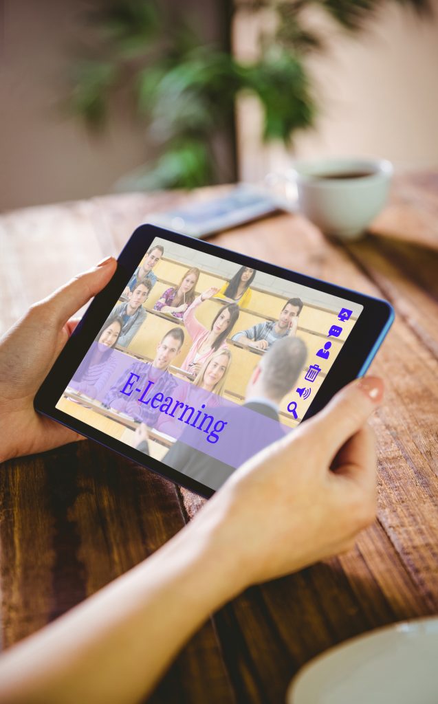 Tablet displaying e-learning platform, wooden table background.