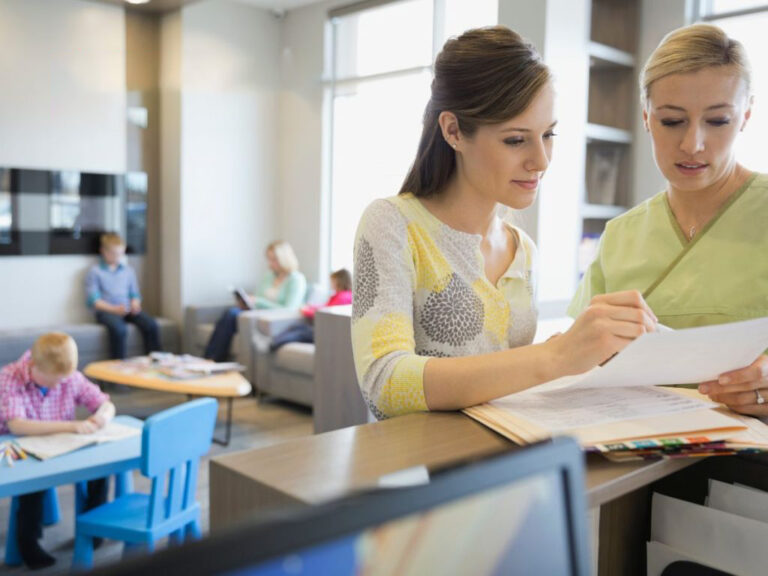 Women reviewing documents in a waiting room.