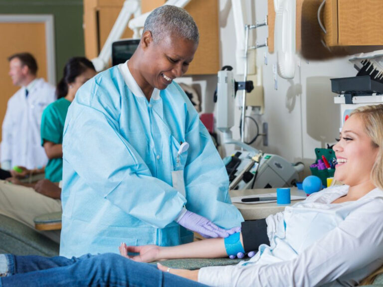 Nurse assisting patient during medical procedure.