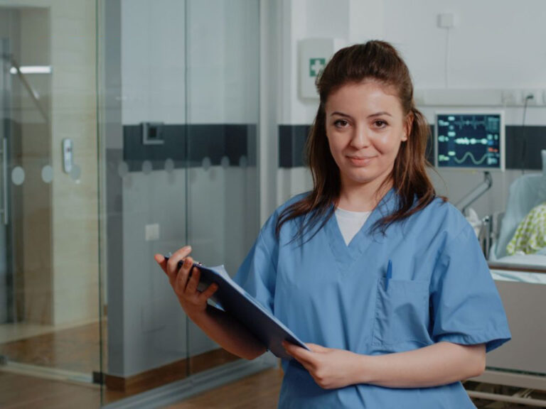 Nurse holding clipboard in hospital room.