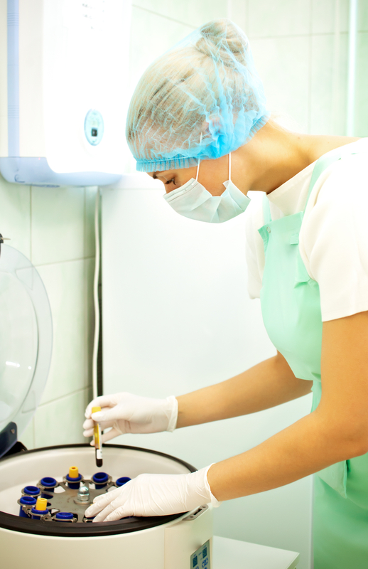 Lab technician using a centrifuge machine.