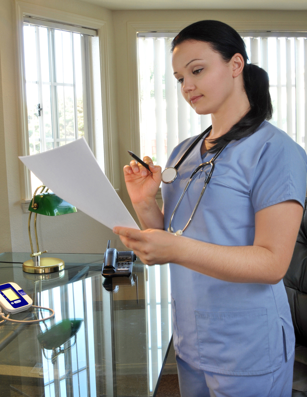 Nurse reviewing paperwork in an office.