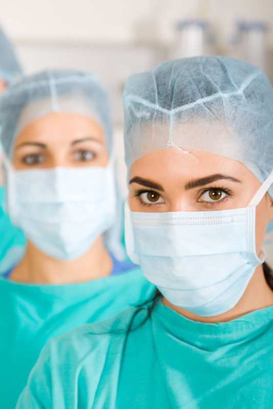 Surgeons wearing masks and scrubs in hospital.
